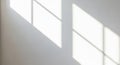 Soft shadows of a window frame cast onto a smooth, light-colored wall. The geometric shapes created Royalty Free Stock Photo