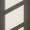 Soft shadows of a window frame create geometric patterns on a beige wall. The light and shadow form Royalty Free Stock Photo