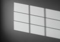 Soft shadows of a window with multiple rectangular panes are projected onto a Royalty Free Stock Photo