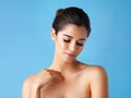 Soft skin and simplistic beauty. Studio shot of a beautiful young woman posing against a blue background.