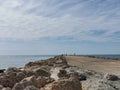 Soft small waves during calm break on granite stones of coastal zone and flow down sand of beach. Sea wave is broken against the Royalty Free Stock Photo