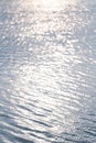 Soft and smooth water wave ripple with blurred bright abstract bokeh of sun light. Royalty Free Stock Photo