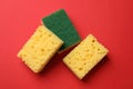 Soft sponges on red background, flat lay. Cleaning tool Royalty Free Stock Photo