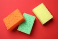Soft sponges on red background, flat lay. Cleaning tool Royalty Free Stock Photo