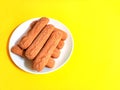 Soft spongy sprinkled sugar vanilla cookies. Classic Argentine pastry. Yellow background. Copyspace