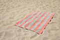 Soft striped beach towel on sunlit sand