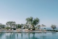 Soft sun loungers under sun umbrellas stand by the pool. Hotel Amanzoe. Peloponnese, Greece Royalty Free Stock Photo