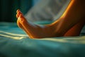 Soft sunlight illuminates a relaxed foot resting on a bed in a tranquil setting Royalty Free Stock Photo
