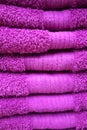 Soft terry towels in purple folded top of each other. Terry towel texture, vertical photo