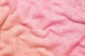 A soft and textured gradient pink knitted fabric with gentle waves and folds, creating a cozy and warm appearance. Ideal