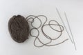 Skein of yarn with knitting needles on a gray background