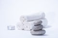 Soft towels, stones and candle for skin care and spa on a white background Royalty Free Stock Photo