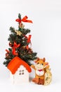 Soft toy bull, toy house with a red roof at the Christmas tree Royalty Free Stock Photo