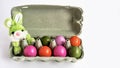 Soft toy green rabbit and colored natural chicken eggs in a papier-mache egg box Royalty Free Stock Photo