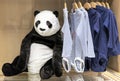 Soft toy panda bear on the background of children`s clothing