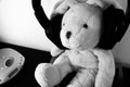 Black and white photo of stuffed plush toy with wireless headphones and a portal CD player