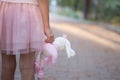 Soft toy rabbit in hands of girl walking in fall park