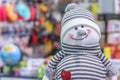 Soft toy smiling snowman in a striped hat and sweater