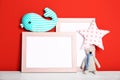 Soft toys and photo frames on table against red background. Child room interior Royalty Free Stock Photo