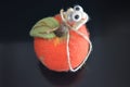 Soft Ukrainian toy made of natural wool and knocked down felt in the form of a bright ripe apple with a cheerful worm located on a Royalty Free Stock Photo