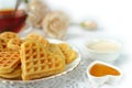 Soft waffles in the shape of a heart in a white plate on a white background close-up