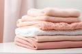 Soft and warm fabric folded in a pile, in various shades of pink and white.