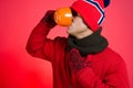A man drinks a hot drink. Cold weather. Red background Royalty Free Stock Photo