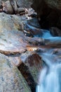 Soft waterfall river with rocks in forest in long exposure