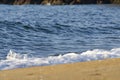 Soft wave hitting sandy beach under bright sunny day Royalty Free Stock Photo