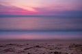 Soft wave at sea beach on blue sky and orange sun setlong exposure shot, purple tone Royalty Free Stock Photo