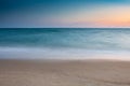 Soft wave at sea beach on blue sky and orange sun set Royalty Free Stock Photo