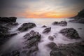 Soft waves of ocean in sunset with stones on the beach