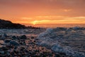 Soft waves on a rocky sunset beach Royalty Free Stock Photo
