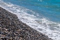 Soft waves on small pebble stones on seashore Royalty Free Stock Photo