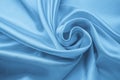 Soft wavy pastel material, blue glossy texture of textile. Satin folds, waves pattern. Silky backdrop with curves, luxury fashion