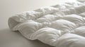 A soft white blanket on white backdrop. Hypoallergenic duvet for year-round comfort