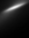A soft white light beam diagonally illuminates a dark black textured background creating a subtle gradient effect and atmospheric Royalty Free Stock Photo