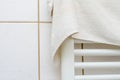 Soft white terry cloth towel drying on a modern heated rack in bathroom Royalty Free Stock Photo