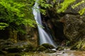 soft white water from a little waterfall between a rocky wall in a forest Royalty Free Stock Photo