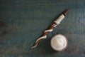 Soft white wool and spindle on blue wooden table, flat lay. Space for text Royalty Free Stock Photo