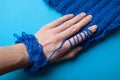 Soft woolen yarn and thread for knitting blue. The hand touches the material