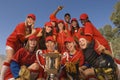 Softball Team And Coach With Trophy Celebrating Against Sky