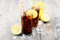 Softdrink with ice cubes, lemon and straw in glass. Royalty Free Stock Photo