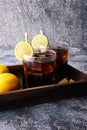 Softdrink with ice cubes, lemon and straw in glass.