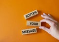 Soften your Message symbol. Concept words Soften your Message on wooden blocks. Beautiful orange background. Businessman hand.