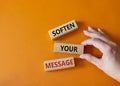 Soften your Message symbol. Concept words Soften your Message on wooden blocks. Beautiful orange background. Businessman hand.