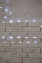 Softly Glowing LED String Lights Against Rustic White Brick Wall Royalty Free Stock Photo