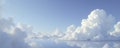 Softly gray clouds float in a vast blue expanse, calm, abstract