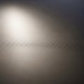A softly lit, close-up view of a textured surface with a fine grid pattern. The surface Royalty Free Stock Photo