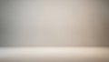 Softly lit empty studio background with a subtle textured wall and floor in neutral beige tones Keywords: softly Royalty Free Stock Photo